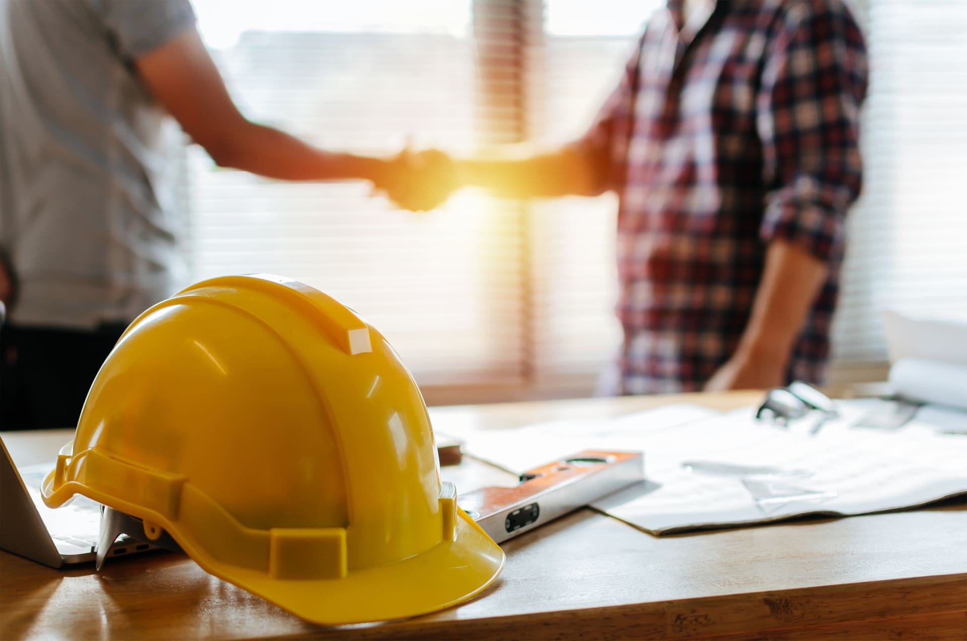 Contractor and client shaking hands over a project agreement