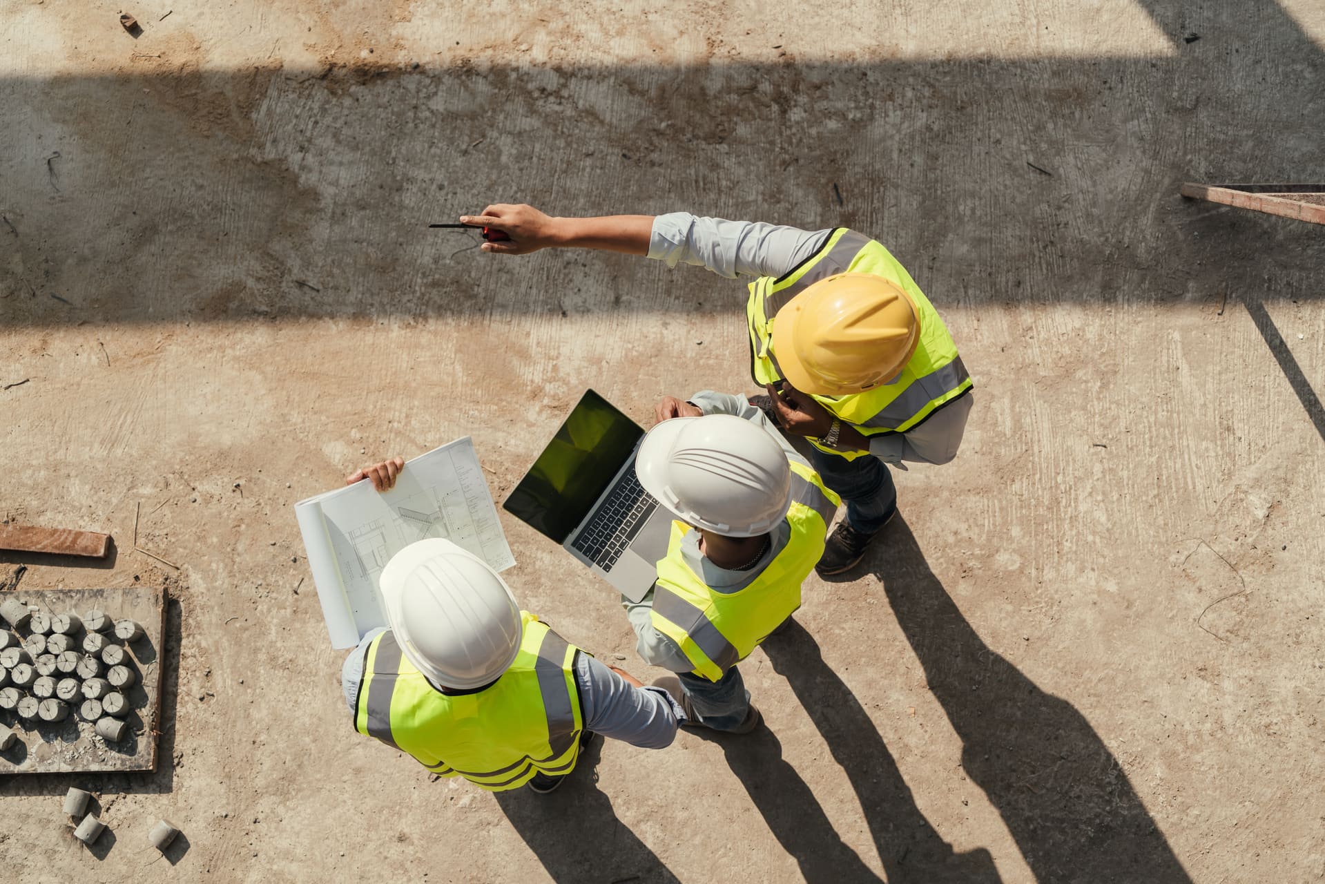 Construction team reviewing plans from above at a jobsite