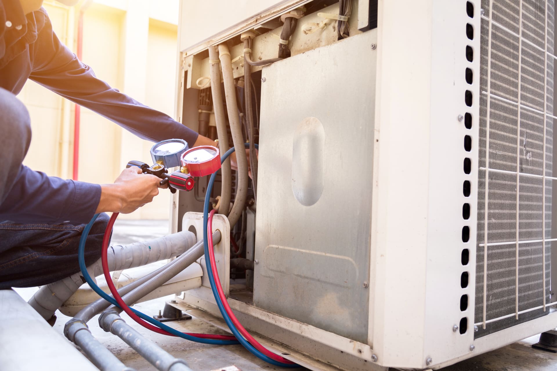 HVAC technician servicing an outdoor air-conditioning unit