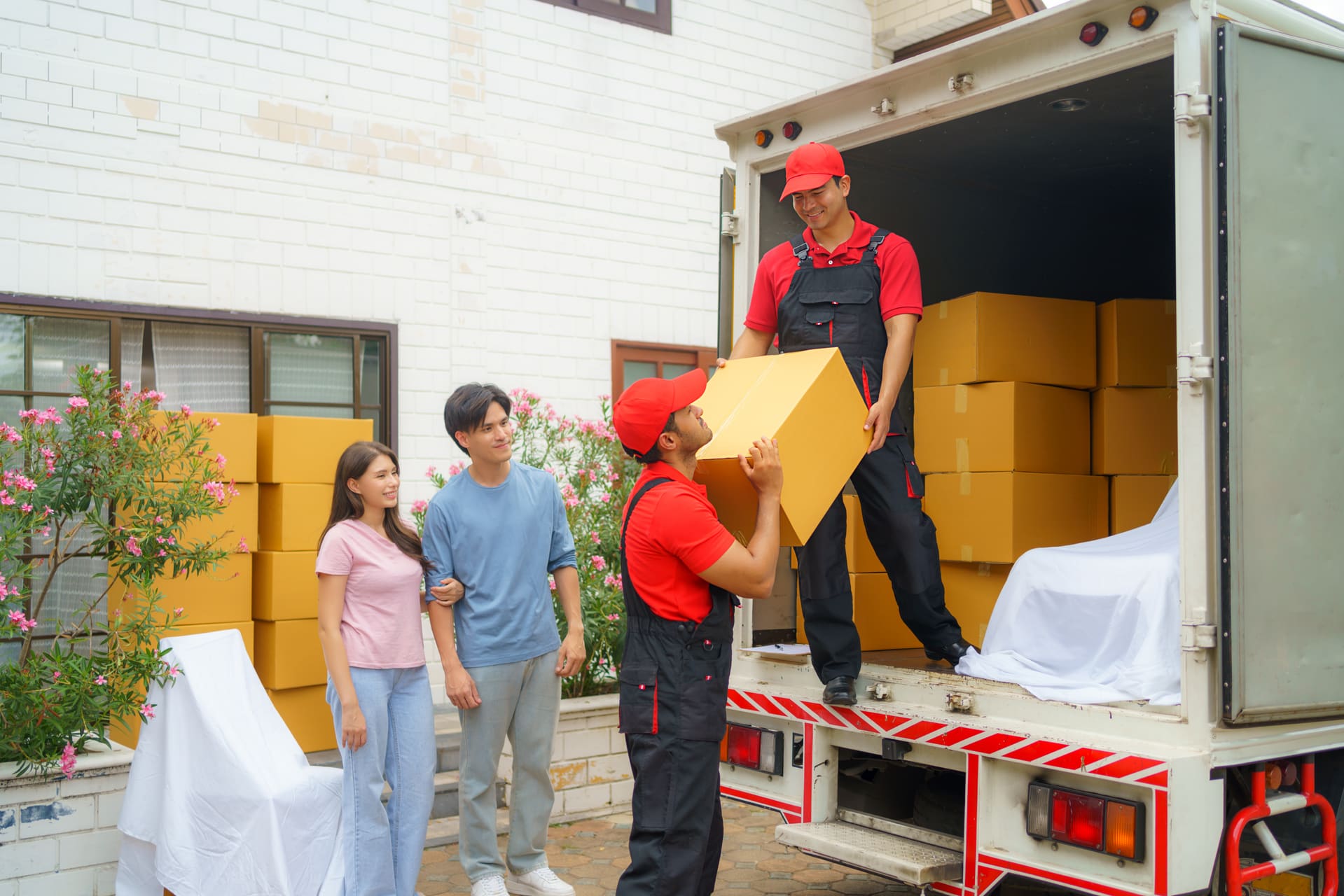 Professional movers unloading boxes for a family