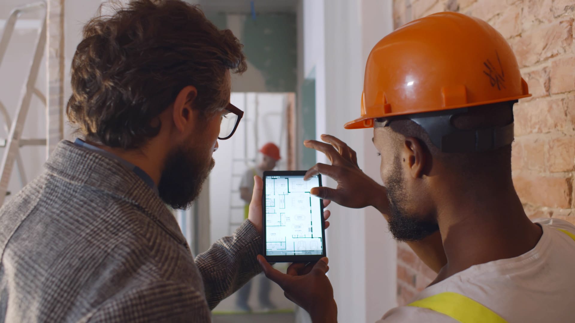 Homeowner and contractor reviewing building plans on a tablet